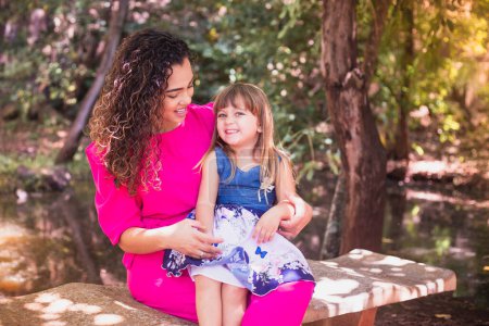 Photo for Mother with her daughter in her lap in the park. Beautiful young mother with her daughter in the park. Mothers Day - Royalty Free Image