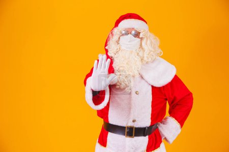 Foto de Real Santa Claus sobre fondo amarillo, con máscara protectora contra el cóvido19. Navidad con distancia social. Covid-19 - Imagen libre de derechos