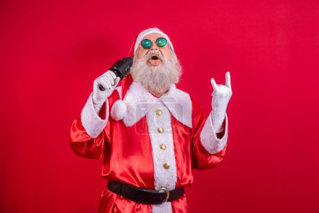 Photo for Crazy Santa Claus singing rock in roll - Royalty Free Image