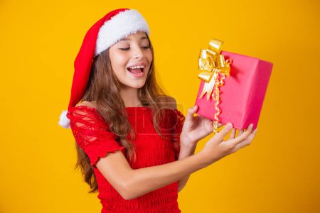 Photo for Excited little Caucasian girl with open mouth holding a Christmas present. - Royalty Free Image
