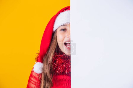 Photo for Happy little girl at Christmas with empty blank poster aside with space for text. - Royalty Free Image