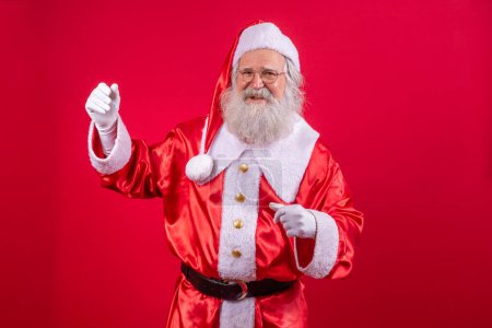 Téléchargez les photos : Père Noël dansant heureux sur fond rouge - en image libre de droit