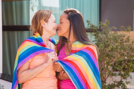 Photo for Lesbian couple with lgbt flag kissing eskimo. valentines day - Royalty Free Image