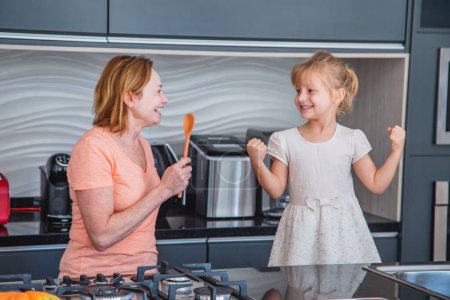 Photo for Happy mother's day! Child daughter and mom cooking and having fun in the kitchen at home. Family holiday and togetherness. - Royalty Free Image
