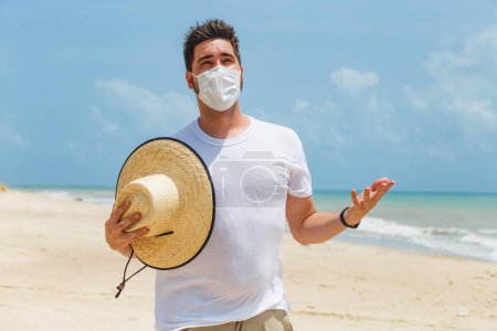 Foto de Primer plano de un joven en la playa con una máscara para protegerse durante la pandemia - Imagen libre de derechos