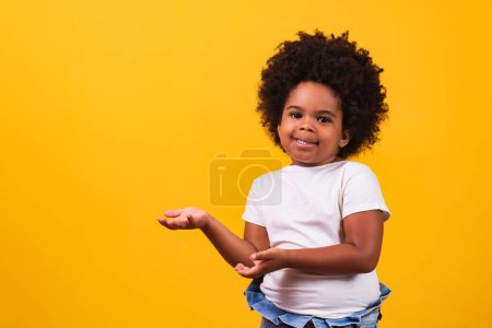 Photo for Black pretty girl points to the left, copy space for some text. little black girl pointing to the side - Royalty Free Image