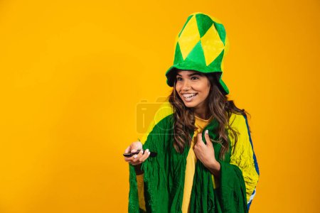 Foto de Joven fan chica brasileña con controlador en la mano listo para ver el partido brasileño - Imagen libre de derechos