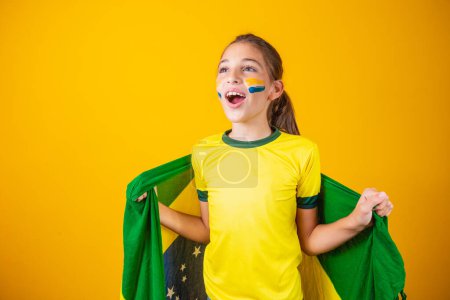 Photo for Football supporter, Brazil team. Beautiful little girl cheering for her team on yellow background - Royalty Free Image
