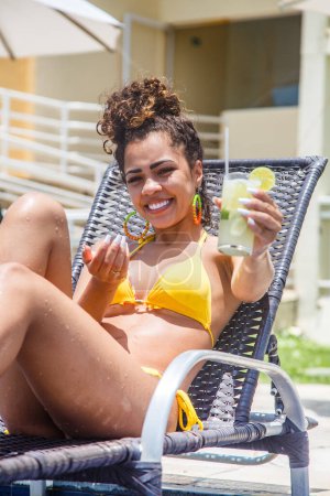 Foto de Mujer joven de vacaciones en la piscina del hotel tomando una deliciosa bebida alcohólica. - Imagen libre de derechos
