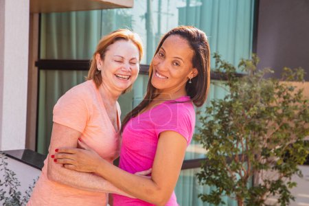 Téléchargez les photos : Couple lesbien souriant sur fond extérieur. Couple lesbien passionné - en image libre de droit