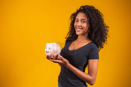 Photo for Young woman with a piggy bank on a solid background - Royalty Free Image