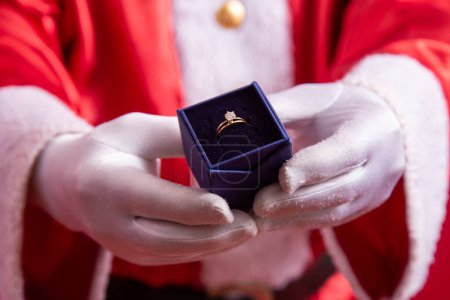 Photo for Close-up of Santa's gloved hand holding a ring. - Royalty Free Image