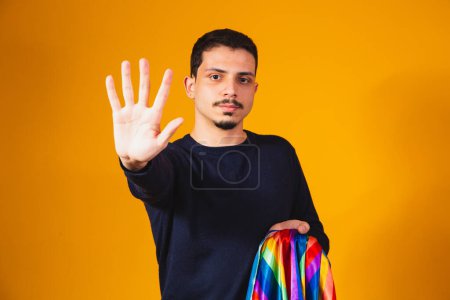 Photo for Gay pride. Homosexual boy with his hand forward making a stop sign to prejudice - Royalty Free Image