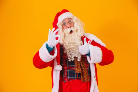 Téléchargez les photos : Père Noël avec le pouce levé donnant un pouce levé ok - en image libre de droit