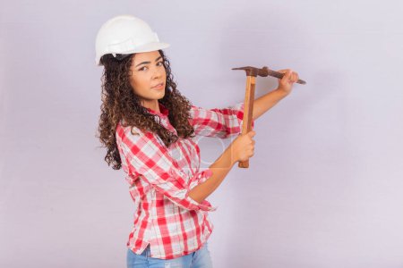 Téléchargez les photos : Entrepreneur femme forant le mur avec un marteau. - en image libre de droit