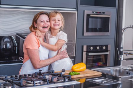 Photo for Happy mother's day! Child daughter and mom cooking and having fun in the kitchen at home. Family holiday and togetherness. - Royalty Free Image