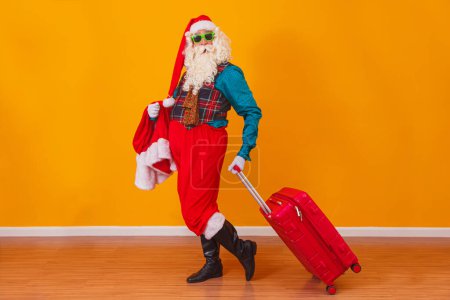 Téléchargez les photos : Le Père Noël avec sa valise. Concept de voyage du Nouvel An. Père Noël à l'aéroport
. - en image libre de droit