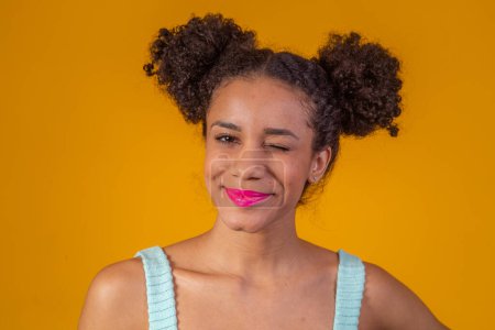 Photo for Beauty portrait of african american woman with afro hairstyle and glamour makeup. Brazilian woman. Mixed race. Curly hair. Hair style. Yellow background. Afro woman smiling at the camera - Royalty Free Image