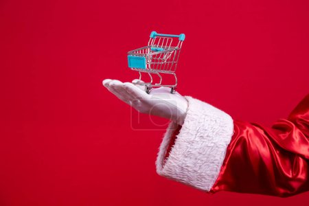 Foto de Santa Claus y el supermercado, que está mostrando un mini carro. Navidad y concepto de compras
. - Imagen libre de derechos