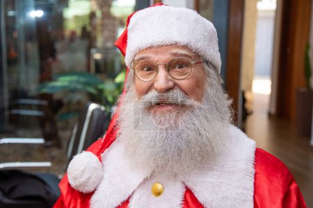 Téléchargez les photos : Le vrai Père Noël, portant des lunettes, des gants et un chapeau regardant droit dans la caméra. Ferme là. Le vrai Père Noël regardant la caméra - en image libre de droit