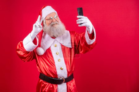 Foto de Santa Claus haciendo una selfie con el smartphone - Imagen libre de derechos