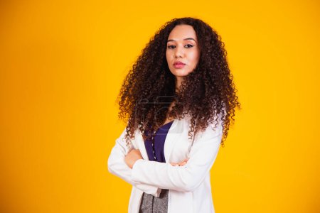 Photo for Young afro business woman with arms crossed on yellow background. - Royalty Free Image