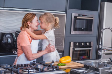 Téléchargez les photos : Bonne fête des mères ! Enfant fille et maman cuisiner et s'amuser dans la cuisine à la maison. Vacances en famille et convivialité
. - en image libre de droit