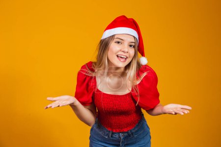 Photo for Image of excited screaming young man standing isolated over yellow background with Santa Claus hat looking at camera with copy space. - Royalty Free Image