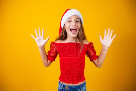Foto de Niña emocionada por la expresiva Navidad sobre fondo amarillo. - Imagen libre de derechos
