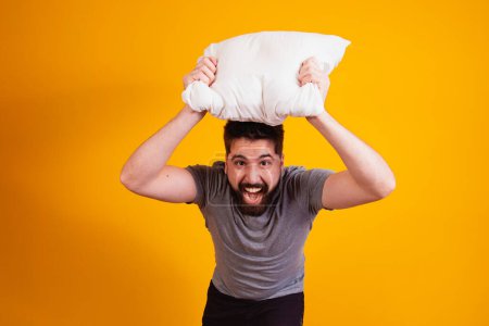 Photo for Fun and playful boy with a pillow in his hand playing pillow war for the camera. - Royalty Free Image
