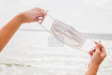 Photo for Portrait of hand holding surgical mask. Holidays and pandemic concept - Royalty Free Image