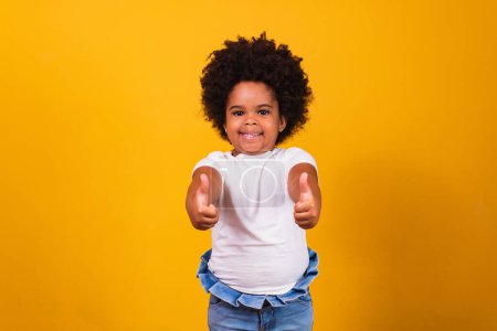 Téléchargez les photos : Petite fille noire avec pouce vers le haut faisant signe ok positif. - en image libre de droit