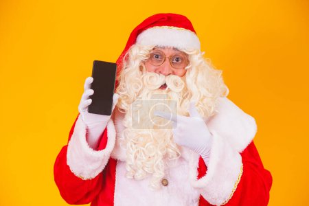 Téléchargez les photos : Père Noël tenant un smartphone dans les mains - en image libre de droit