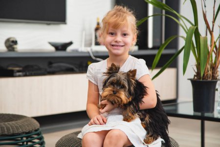 Photo for Close up little girl  holding a pet. Girl holding a dog - Royalty Free Image