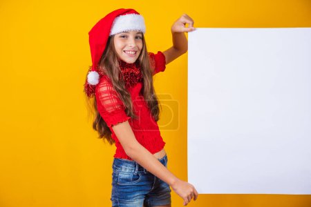 Happy little girl at Christmas with empty blank poster aside with space for text. Poster 655790676