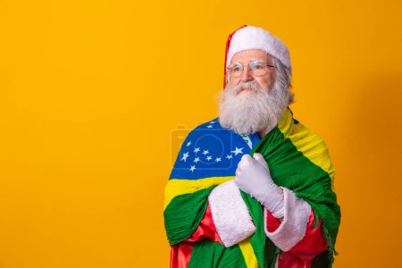 Foto de Santa Claus es un fan de Brasil. Santa Claus fan de la selección brasileña. Campeonato de Deportes. Santa Claus con la bandera brasileña. Partido de fútbol. - Imagen libre de derechos