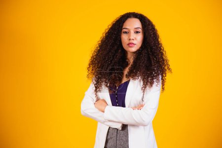 Photo for Young afro business woman with arms crossed on yellow background. - Royalty Free Image