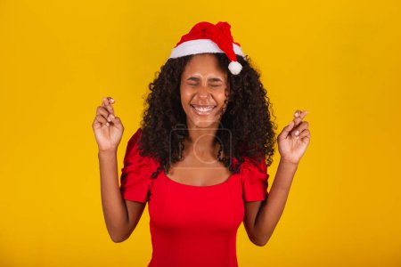 Téléchargez les photos : Expressive femme excitée avec Santa Hat sur fond jaune. - en image libre de droit