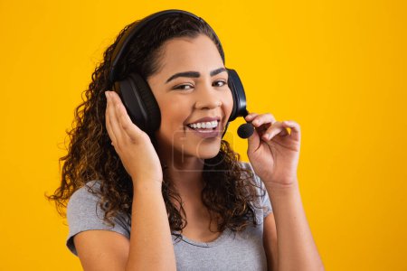 Photo for Contact the call center service. Customer support, female sales agent. Caller or operator of telephone operator or business woman in headset. Afro young woman. Zoom conference. yellow  background - Royalty Free Image