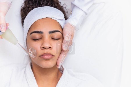 Photo for Darsonval cosmetology apparatus. Face cleaning procedure. Salon skincare treatment. Professional dermatology hardware. Electric spa equipment. Medicine patient device. Removal acne - Royalty Free Image