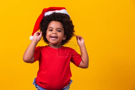 Téléchargez les photos : Petite fille afro enfant avec chapeau de Père Noël. - en image libre de droit