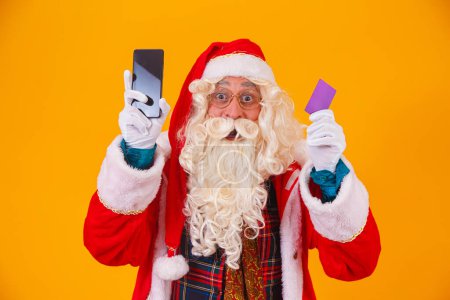 Foto de Santa Claus usando tarjeta de crédito para pagar las compras por internet - Imagen libre de derechos