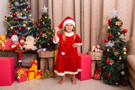 Photo for Cute little caucasian girl dressed for christmas at home. Girl on Christmas background dressed in noelete - Royalty Free Image