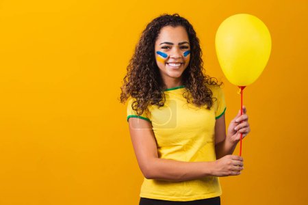 Photo for Brazilian fan holding a yellow balloon with free space for text. Brazil game promotion - Royalty Free Image