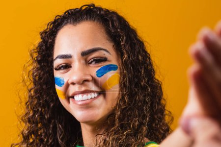 Téléchargez les photos : Eventail brésilien avec visage peint prenant un selfie - en image libre de droit