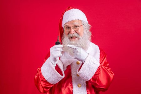 Foto de Santa Claus sosteniendo las llaves de un coche sobre fondo rojo - Imagen libre de derechos