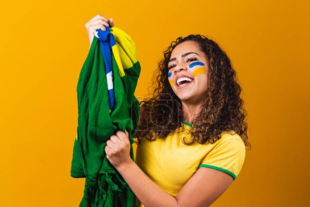 Téléchargez les photos : Éventail brésilien avec son visage peint en bleu et jaune pour le b - en image libre de droit