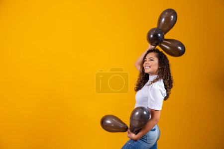 Téléchargez les photos : Jeune femme célébrant sa fête d'anniversaire avec un tas de ballons à air. - en image libre de droit