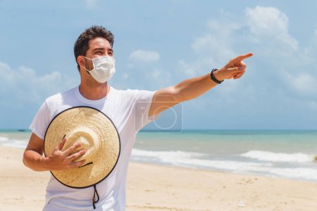 Foto de Primer plano de un joven en la playa con una máscara para protegerse durante la pandemia - Imagen libre de derechos