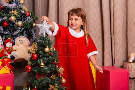 Foto de Niño caucásico organizar decorar árbol de Navidad con diversión y alegre concepto de ideas festivas de Navidad - Imagen libre de derechos